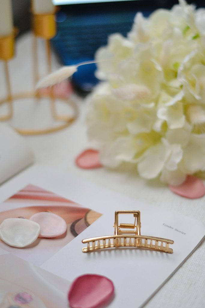 golden-hair-clip-on-a-floral-and-decorative-table-n8t2izxacnq